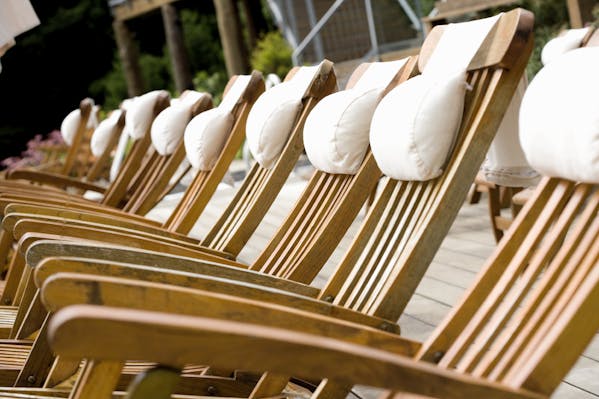 Liegestühle aus resistentem Holz mit weißen Kopfkissen